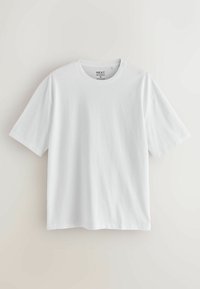 T-shirt en coton blanc uni de taille moyenne avec manches courtes et col rond, présenté sur un fond neutre.