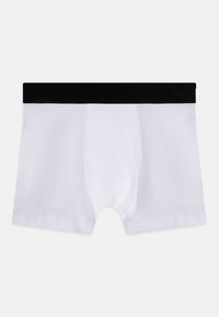 Hvite boksershorts laget av myk stoff, med svart elastisk livsband med logo, glatt tekstur og en tettsittende form.