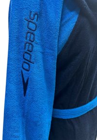 Accappatoio blu e nero realizzato in morbido tessuto di spugna; presenta il logo Speedo ricamato in blu scuro nell'area del colletto e una cintura coordinata.