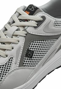 Chaussures de sport grises et blanches avec des panneaux en maille, semelle en caoutchouc, cuir texturé, lacets proéminents et étiquette de marque avec "QS."