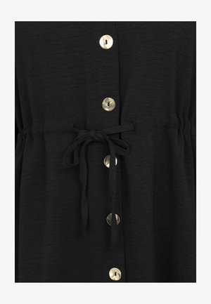 Sort stofbeklædning med snøre i taljen, prydet med store runde guldknapper foran og en blød, tekstureret overflade.