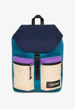 Teal rugzak met een marineblauwe klep, twee crèmekleurige voorzakken met paarse randen en een zwarte gesp sluiting. Eastpak-logo aan de onderkant.
