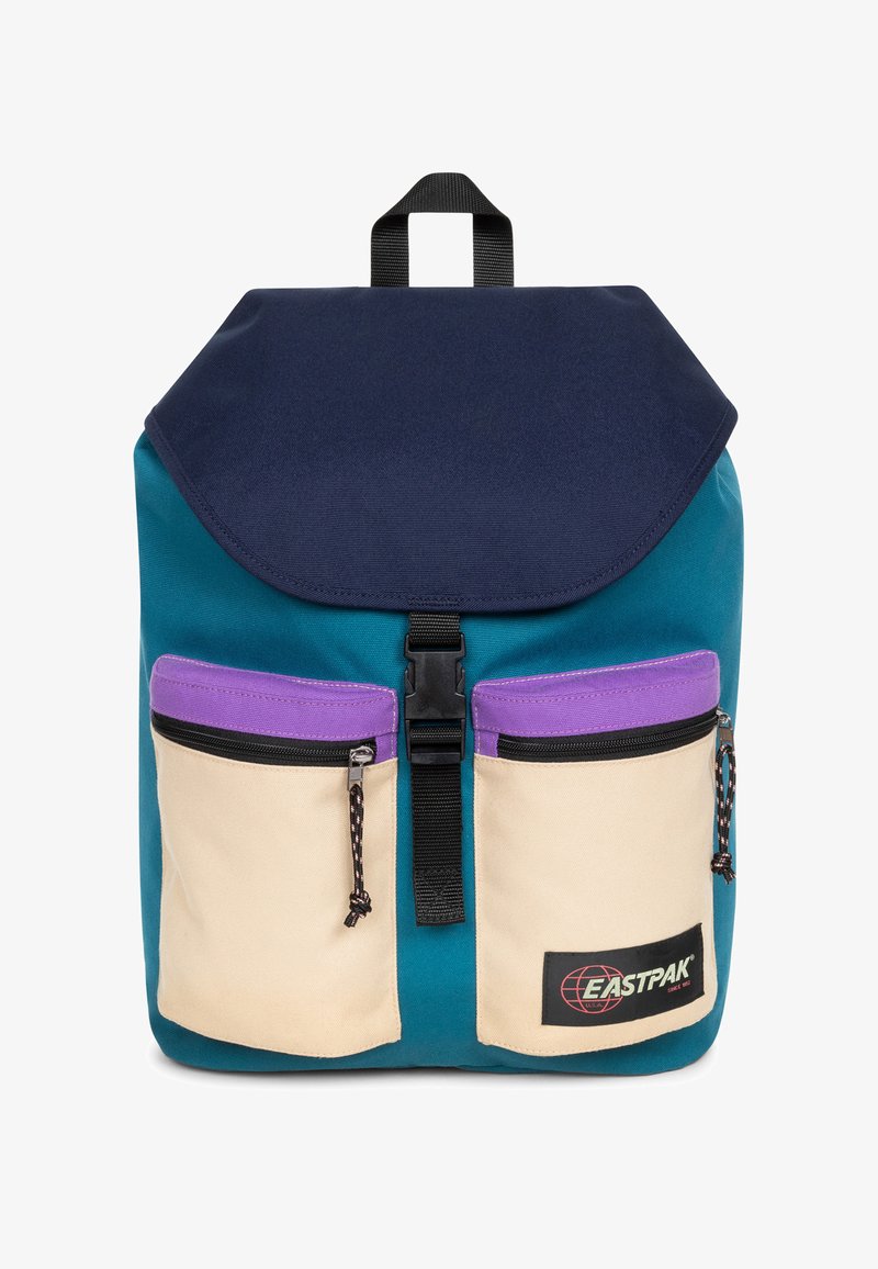 Teal rugzak met een marineblauwe klep, twee crèmekleurige voorzakken met paarse randen en een zwarte gesp sluiting. Eastpak-logo aan de onderkant.
