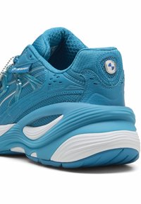 Pantof cu design sport de culoare turquoise, având un superior din plasă texturată, accente din piele netedă și un design al tălpii compus din straturi, evidențiat prin detalii albe și logo.