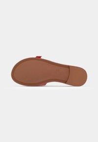 Semelle de chaussure en marron clair avec une texture lisse. Présente un design épais et arrondi, avec des rainures subtiles le long des bords. Simple et fonctionnelle.