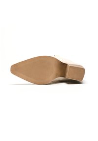 Suela de zapato beige con una superficie lisa y texturizada; presenta un tacón bajo tipo bloque y una suela de goma contrastante con un patrón estriado para mayor agarre.