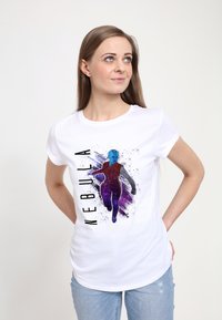 Biała bawełniana koszulka z niebieską ilustracją postaci, z fioletowym i czarnym wzorem plam, oraz napisem "NEBULA" napisanym pogrubioną czcionką.