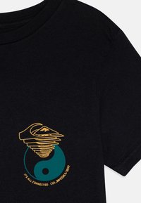 Juodas medvilninis marškinėliai su daugiaspalviu grafikiniu dizainu, vaizduojančiu spiralę ir yin-yang simbolį, bei užrašu "VISKAS YRA SUSIJĘ."
