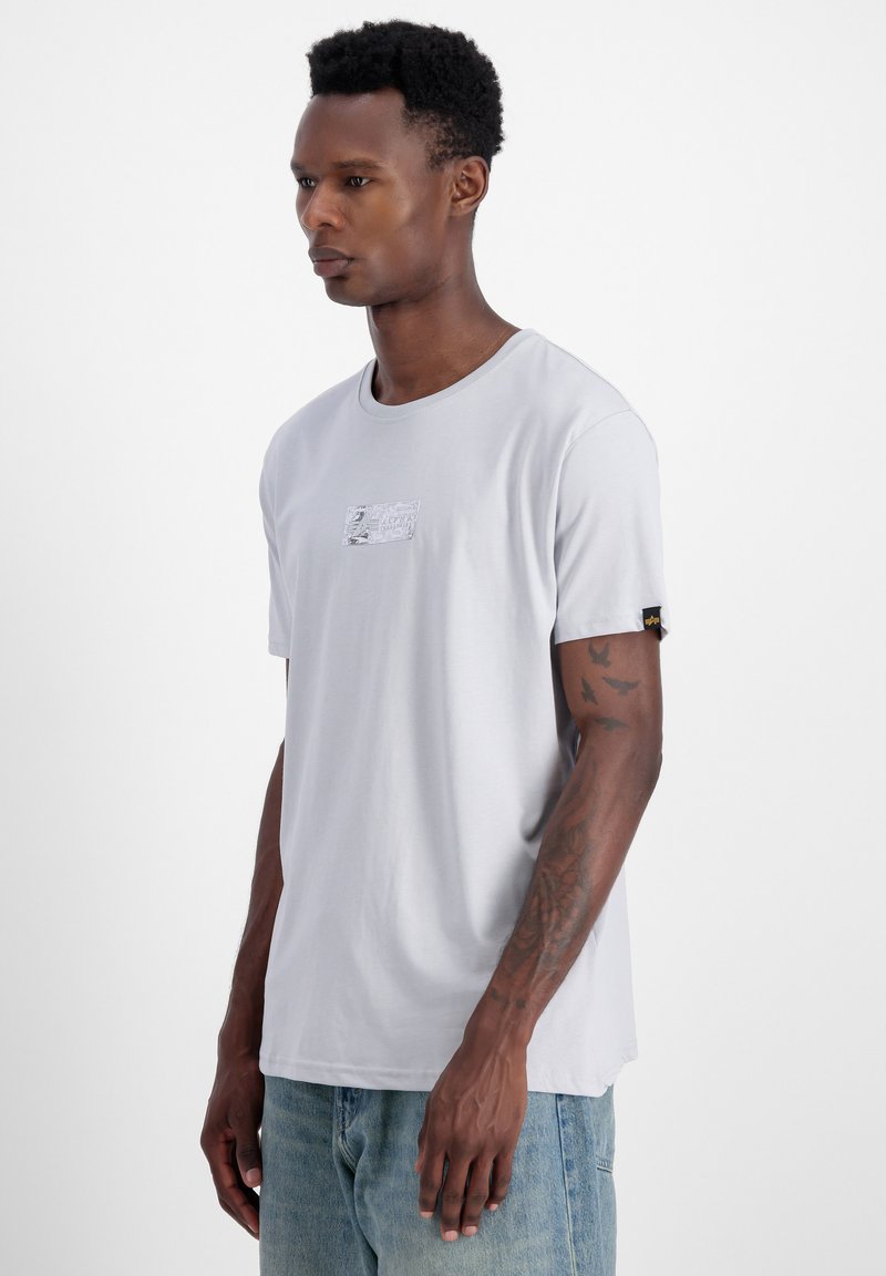 Gaiši pelēks īsām piedurknēm t-krekls ar apaļu kakla izgriezumu un mazu izšūtu uzpleču uz krūtīm. Mīksta tekstūra, ikdienišķs griezums un neliela stiepšanās.