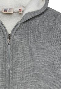 Szara bluza z kapturem na zamek błyskawiczny, wykonana z dzianiny o fakturze, z polarem w środku oraz ściągaczami na krawędziach. Posiada metalowy zamek oraz metkę z nazwą marki i rozmiarem (XL).