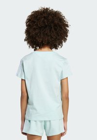 Light pastel blue cotton t-shirt with short sleeves, a crew neckline, and a relaxed fit. Notable shoulder panels in white.