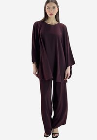 Bordeauxfarbenes zweiteiliges Outfit mit einer locker sitzenden Tunika mit weiten Ärmeln und passenden Hosen mit weitem Bein, gefertigt aus weichem, fließendem Stoff.