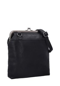 Schwarze Lederhandtasche mit strukturierter Form, Metallschnappverschluss, verstellbarem Trageriemen und glatter Textur, die minimalistische Designdetails aufweist.