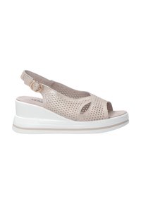 Beige perforované kožené dámské sandály na klínu, které mají otevřenou špičku, zavazování na patě se zlatým kruhovým sponou a bílou podrážku.