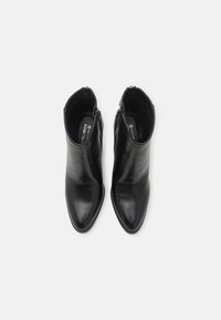 Schwarze Lederstiefeletten mit spitzem Schuhblatt und glatter Textur. Besitzen einen seitlichen Reißverschluss und einen niedrigen Absatz für einen bequemen Tragekomfort.