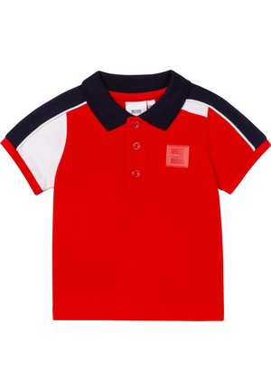 Rotes Polohemd für Kleinkinder mit marineblauem Kragen und Schultern, weißen Akzenten an den Schultern, drei roten Knöpfen und einem kleinen quadratischen Logoaufnäher auf der Brust.