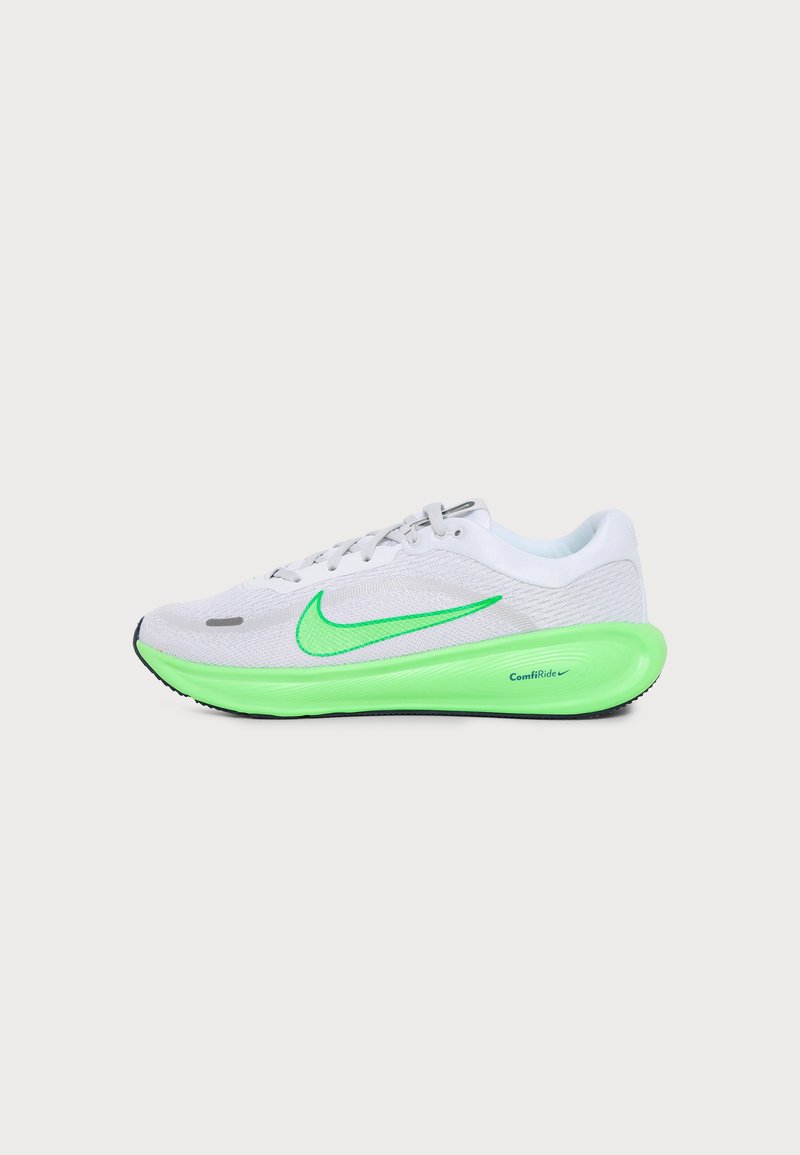 Λευκό και πράσινο αθλητικό παπούτσι Nike με φωτεινή πράσινη σόλα και λογότυπο Swoosh, με απορρόφηση κραδασμών ComfiRide σε απλό φόντο.