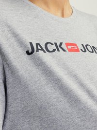 Grå bomull t-skjorte med en svart og rød logo som står "JACK & JONES" på brystet, med rund halsdesign.