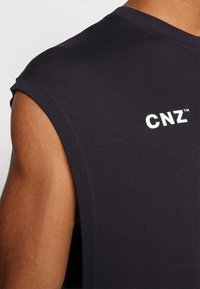 Camiseta sin mangas negra con una textura suave y un escote redondeado, que presenta un logotipo blanco "CNZ" en la parte delantera.