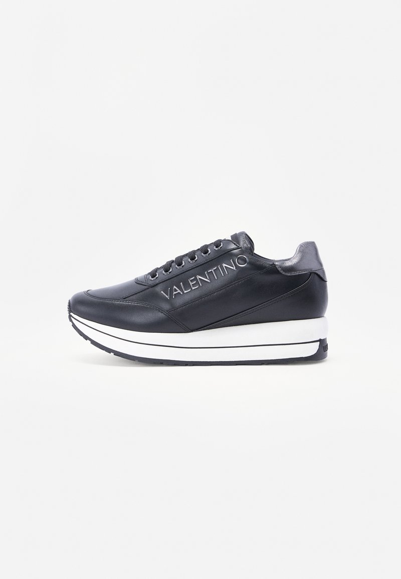 Zwarte leren sneakers met een witte zool en een opvallend logo aan de zijkant. Ronde neus en vetersluiting met textuuraccenten.