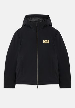 Black insulated jacket with a hood, featuring a gold logo, front zipper, and side pockets. Smooth texture with a minimalist design.