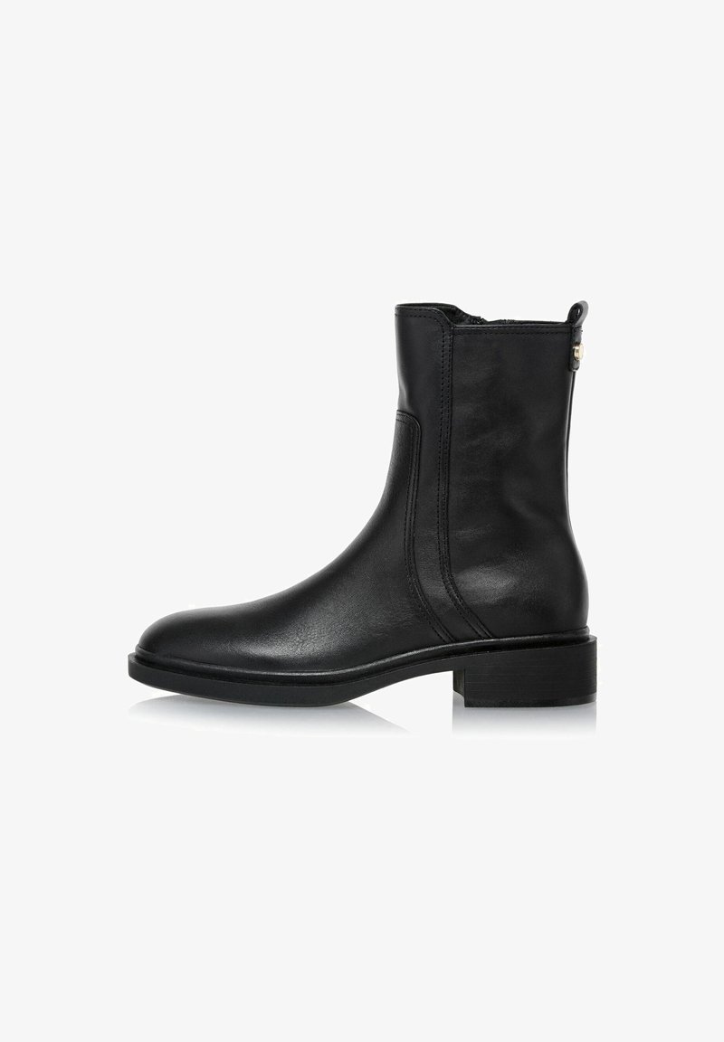 Czarne skórzane botki za kostkę o gładkim wykończeniu, zaokrąglonym czubku i minimalistycznym designie. Posiadają boczny zamek i niski obcas w kształcie kostki.