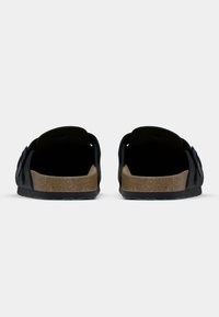 Μαύρα ανοιχτά σανδάλια με δύο λουριά, πάτο από φελλό και ελαστική σόλα. Διαθέτουν λεία υφή και στρογγυλεμένο σχήμα.