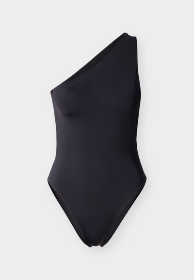 Ολόσωμο μαγιό σε μονόχρωμο μαύρο, με σχεδίαση ενός ώμου. Κατασκευασμένο από απαλό, ελαστικό ύφασμα με μινιμαλιστική σιλουέτα.