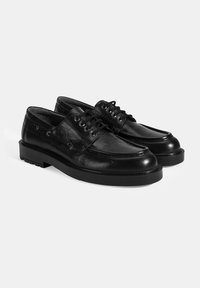 Schwarze Lederschuhe mit strukturiertem Oberflächen, runder Zehenform, Schnürdesign und verstärkter Gummisohle. Verfügt über sechs Ösen für die Schnürsenkel.