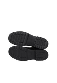 Sole in gomma nera con motivi di grip testurizzati, caratterizzata da righe orizzontali e un'accenno rettangolare. Design elegante e resistente.