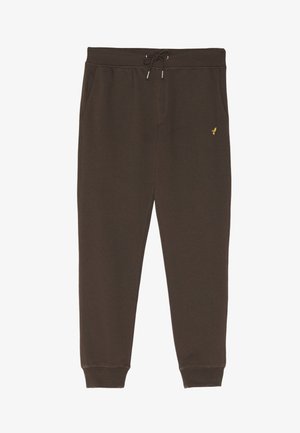 Pantalon de survêtement marron en tissu doux, avec une taille élastique dotée d'un cordon de serrage, des poches latérales et un petit logo doré.