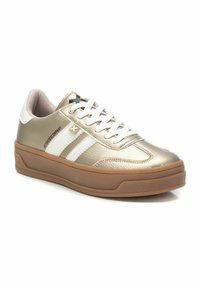 Sneakers metálicos dorados con rayas blancas, parte superior texturizada, suela de goma y cierre de cordones. Diseño elegante con un mínimo detalle de marca.