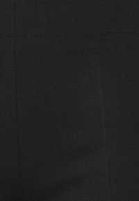 Tissu noir avec une texture lisse et un léger éclat, présentant des détails de couture subtils et un design simple et uniforme.