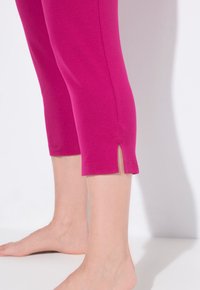 Fuchsia capri leggings made of soft cotton with a slight slit at the hem. Smooth texture with a fitted design, suitable for casual wear.