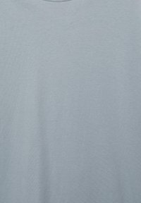 Svetlo sivo-modra enobarvna tkanina z nežnim vzorcem pletenine in mehkimi senci, verjetno del oblačila.