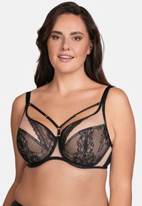 Black lace bra with sheer panels, featuring gold hardware accents and a strappy design. It has underwire support and adjustable straps.