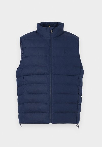 Αμάνικο κοντό μπουφάν σε ναυτικό μπλε χρώμα με καπιτονέ σχέδιο, ψηλό γιακά και φερμουάρ μπροστά, με διακριτικό κεντημένο λογότυπο στο στήθος.