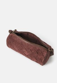 Piccola borsetta in pelle scamosciata borgogna, intrecciata, con chiusura a zip, bordata da una foderatura interna liscia e dotata di un anello laterale per il fissaggio.