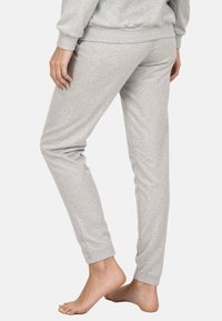 Szürke pamut melegítőnadrág, testhezálló szabással, egyenes szárakkal és rugalmas derékpánttal, sima felülettel és látható minták nélkül.