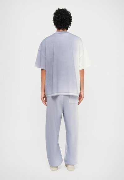 Tricou oversized de lavandă estompată și pantaloni de trening asortați, cu un croi lejer și material moale, având un gradient subtil de la deschis la închis.