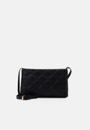 Borsa a tracolla in pelle nera trapuntata con tracolla regolabile e fibbia color oro su sfondo semplice.
