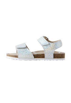 Glitrende hvide sandaler med to justerbare velcrobånd, brun korksål og hvid struktureret ydersål. Åben tå-design for åndbarhed.