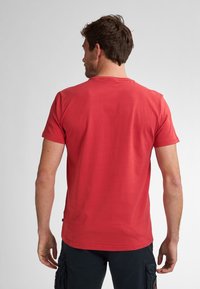 Camiseta roja de manga corta con cuello redondo, hecha de tejido de algodón. Textura suave sin patrones ni elementos metálicos, diseño ajustado.