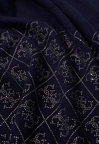 Tessuto blu navy con un design testurizzato caratterizzato da accenti di perline argentate in un motivo geometrico. Il materiale appare morbido e lavorato a maglia.