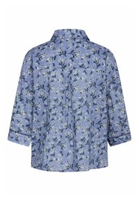 Camisa de botones azul con estampado floral, presentando mangas tres cuartos, con un patrón de flores blancas y hojas verdes sobre una tela texturizada.