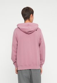 Hue sweatshirt i lyserød, lavet af blødt stof, med ribbede manchetter og kant, i en afslappet pasform og minimal branding detalje.
