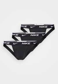 Schwarze Baumwollslips mit weißem Nike-Bundlogo, im niedrigen Schnitt und mit glatter Textur. Drei Paar sind in einem Stapel angeordnet.