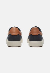 Marine sneakers met bruin leren accenten, met een laag model, gestructureerde bovenkant en een witte rubberen zool. Achteraanzicht weergegeven.