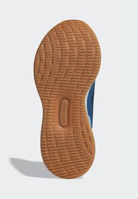 Suola esterna in gomma con motivo zigrinato, caratterizzata da una base di colore marrone e scanalature per la trazione; i bordi si assottigliano verso il tallone e i lati.