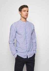 Long-sleeve, button-up shirt made of light fabric with blue and white vertical stripes, featuring a band collar and straight hem.